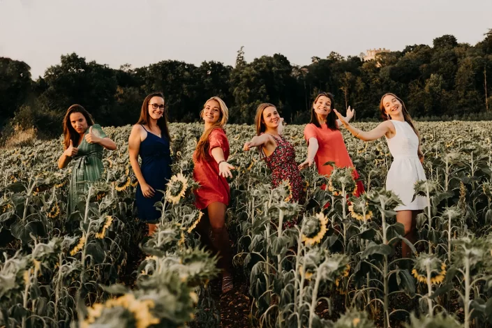 Séance photo entre amies dans un champ de tournesols