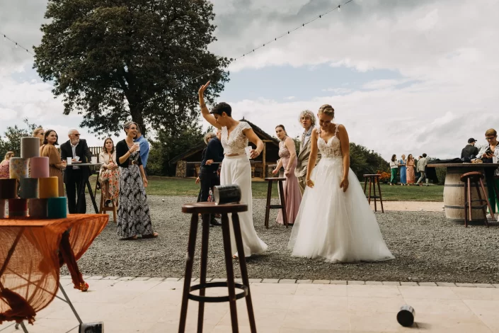 Les mariées qui jouent au chamboule-tout pendant leur mariage - Mariage au Domaine du Bois Menias